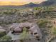 Aerial view of a luxurious home with desert landscaping, tile roof, and mountain views at 11400 E Helm Dr, Scottsdale, AZ 85255