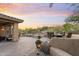 Spacious backyard featuring a desert landscape, a covered seating area, and a charming fire pit at 11400 E Helm Dr, Scottsdale, AZ 85255