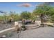 Inviting backyard featuring a cozy fire pit area surrounded by lush desert landscaping and comfortable seating at 11400 E Helm Dr, Scottsdale, AZ 85255