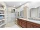 Elegant bathroom boasts double sink vanity, granite countertop, frameless shower, and custom shelving at 11400 E Helm Dr, Scottsdale, AZ 85255