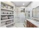 Elegant bathroom featuring a frameless shower, custom shelving, and neutral tiling at 11400 E Helm Dr, Scottsdale, AZ 85255