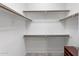 Walk-in closet offers built-in shelving and wooden rods for optimal storage at 11400 E Helm Dr, Scottsdale, AZ 85255
