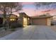 Charming home exterior with a private drive and well-maintained desert landscaping under a vivid sunset sky at 11400 E Helm Dr, Scottsdale, AZ 85255