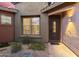Inviting front entrance showcasing a secure iron door, tasteful lighting, and low-maintenance desert landscaping at 11400 E Helm Dr, Scottsdale, AZ 85255