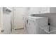 Bright laundry room with washer, dryer, storage cabinets, and painted cactus accent at 11400 E Helm Dr, Scottsdale, AZ 85255