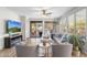 Bright living room featuring a cozy fireplace, ceiling fan, and sliding glass doors to a covered patio at 11400 E Helm Dr, Scottsdale, AZ 85255