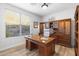 Well-appointed home office with classic wood desk, custom shelves, and natural light at 11400 E Helm Dr, Scottsdale, AZ 85255