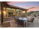 Covered outdoor brick patio with seating area, offering views of the surrounding desert landscape at 11400 E Helm Dr, Scottsdale, AZ 85255