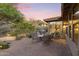 Outdoor patio area with seating and grill, sliding glass door reveals view into the dining and kitchen at 11400 E Helm Dr, Scottsdale, AZ 85255