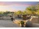 Comfortable outdoor seating area on a brick patio with desert landscape and gorgeous sunset view at 11400 E Helm Dr, Scottsdale, AZ 85255