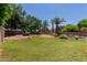 Expansive backyard with mature trees, a stone patio, and lush green grass at 115 E Spur Ave, Gilbert, AZ 85296