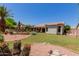 Private backyard with custom water feature, mature desert landscaping, and lush grass at 115 E Spur Ave, Gilbert, AZ 85296