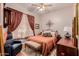 Cozy bedroom with decorative headboard, rich drapes, complemented by hardwood floors and decorative lamps at 115 E Spur Ave, Gilbert, AZ 85296
