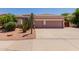 Charming single-story home featuring a two-car garage and desert landscaping with mature cactus and shrubs at 115 E Spur Ave, Gilbert, AZ 85296