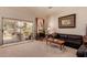 Cozy living room featuring a plush sofa, rocking chair, and sliding glass doors leading to a landscaped backyard at 115 E Spur Ave, Gilbert, AZ 85296