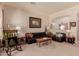 Inviting living room with comfortable leather seating, complemented by a vintage rug and classic artwork at 115 E Spur Ave, Gilbert, AZ 85296
