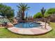 Inviting pool featuring a rock waterfall, mature landscaping, and a convenient handrail for easy access at 115 E Spur Ave, Gilbert, AZ 85296