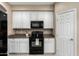 Modern kitchen with white cabinets, black appliances, and granite countertops, offering functionality and style at 12023 W Duane Ln, Peoria, AZ 85383
