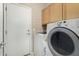 Functional laundry room equipped with modern appliances and built-in storage cabinets at 12023 W Duane Ln, Peoria, AZ 85383