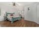 Bright main bedroom boasts wood floors, ceiling fan, large bed, and a quaint window at 12023 W Duane Ln, Peoria, AZ 85383