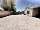 Expansive backyard with brick pavers, small grass area, and block wall offering space and privacy at 1339 W Mesquite Ave, Apache Junction, AZ 85120