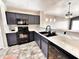 Modern kitchen with black appliances, sleek countertops, tile floors, and dark gray cabinets at 1339 W Mesquite Ave, Apache Junction, AZ 85120