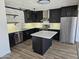 Beautiful modern kitchen with a stainless steel refrigerator, sleek black cabinets, and marble countertops at 13801 N 37Th Dr, Phoenix, AZ 85053