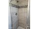Close-up of the tiled shower with mosaic accent at 13801 N 37Th Dr, Phoenix, AZ 85053