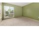 Bedroom with green walls, carpet flooring, and a large window providing plenty of natural light at 14224 N Newcastle Dr, Sun City, AZ 85351