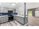 Modern kitchen features grey cabinetry, stainless appliances, blue backsplash, and wood grain floors at 14224 N Newcastle Dr, Sun City, AZ 85351