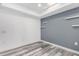 Modern living room features grey accent wall, wood grain floors, and plenty of space at 14224 N Newcastle Dr, Sun City, AZ 85351