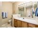 Well-lit bathroom with a large mirror, a single sink vanity, and a separate toilet area for added privacy at 14950 W Mountain View Blvd # 5306, Surprise, AZ 85374