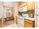 Functional kitchen with white appliances, wood cabinets, and a view into the dining space at 14950 W Mountain View Blvd # 5306, Surprise, AZ 85374