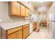 Kitchen with ample wood cabinets, a white countertop, and a view into the dining area at 14950 W Mountain View Blvd # 5306, Surprise, AZ 85374