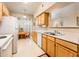 Well-lit kitchen featuring white appliances and wood cabinetry, offering a functional layout at 14950 W Mountain View Blvd # 5306, Surprise, AZ 85374