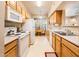 Efficient kitchen with white appliances and wood cabinets, adjacent to a breakfast nook at 14950 W Mountain View Blvd # 5306, Surprise, AZ 85374