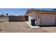 View of the home's front yard, featuring desert landscaping and a side driveway with a rolling trash bin at 1586 S Lawther Dr, Apache Junction, AZ 85120