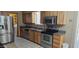 A well-lit kitchen with stainless steel appliances, tile flooring, and wooden cabinets at 1586 S Lawther Dr, Apache Junction, AZ 85120