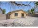 This backyard features an outdoor space with stone pavers, a metal gate, and a covered patio at 16159 W Maui Ln, Surprise, AZ 85379