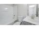 A clean bathroom features a shower-tub, white toilet, and a single sink with a gray cabinet at 16159 W Maui Ln, Surprise, AZ 85379