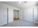 A simple bedroom has plush carpet, closet space, and an adjacent room is visible through an open door at 16159 W Maui Ln, Surprise, AZ 85379