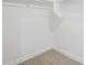 A simple walk-in closet is carpeted with white walls, offering basic storage solutions at 16159 W Maui Ln, Surprise, AZ 85379
