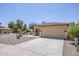 Exterior view of a well-maintained home with a tile roof, desert landscaping, and a long driveway leading to a two-car garage at 16159 W Maui Ln, Surprise, AZ 85379