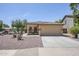 This home features a desert landscape with a spacious driveway leading to a two-car attached garage at 16159 W Maui Ln, Surprise, AZ 85379