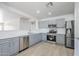 A well-lit kitchen featuring stainless steel appliances, light gray cabinets, and quartz countertops at 16159 W Maui Ln, Surprise, AZ 85379