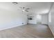 A bright living room features wood floors, ceiling fan, and an open floor plan adjacent to the kitchen at 16159 W Maui Ln, Surprise, AZ 85379