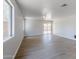 A spacious living room with wood floors, ceiling fan, and a sliding glass door leading to the backyard at 16159 W Maui Ln, Surprise, AZ 85379