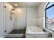 Modern bathroom with glass shower, soaking tub, and elegant tile work at 16202 N 61St Ave, Glendale, AZ 85306