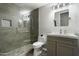 Beautiful bathroom with tiled shower, glass door, pebble floor and modern sink with grey cabinets at 16202 N 61St Ave, Glendale, AZ 85306