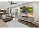 Bright living room features a comfy couch, ceiling fan, and a large TV at 16202 N 61St Ave, Glendale, AZ 85306